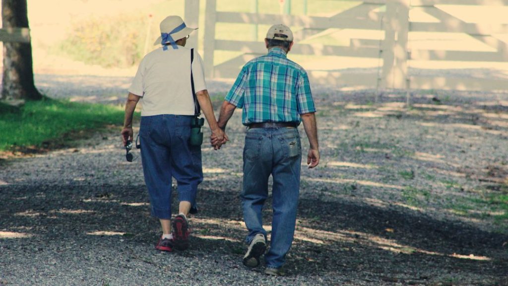 elderly couple walking on gravel path