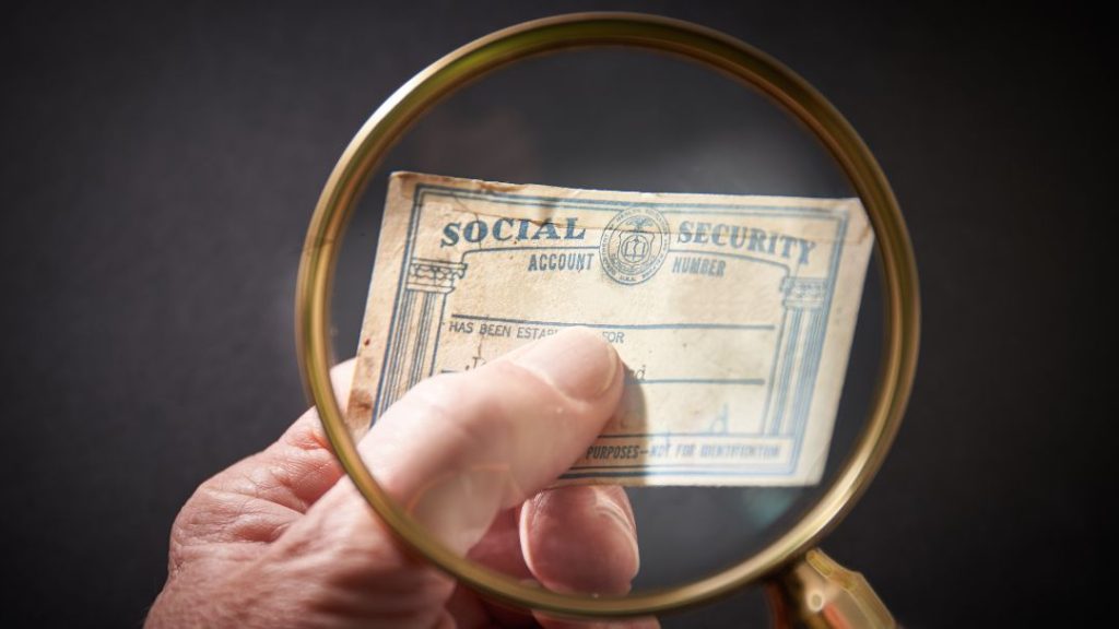 worn social security card under magnifying glass