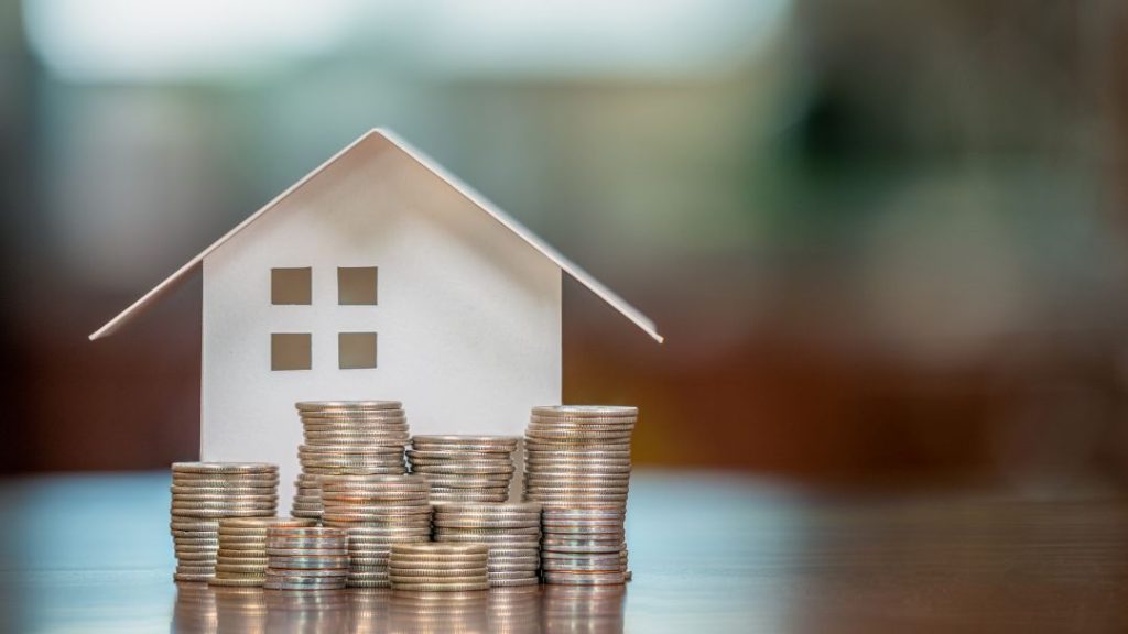 house model with stacks of coins in front