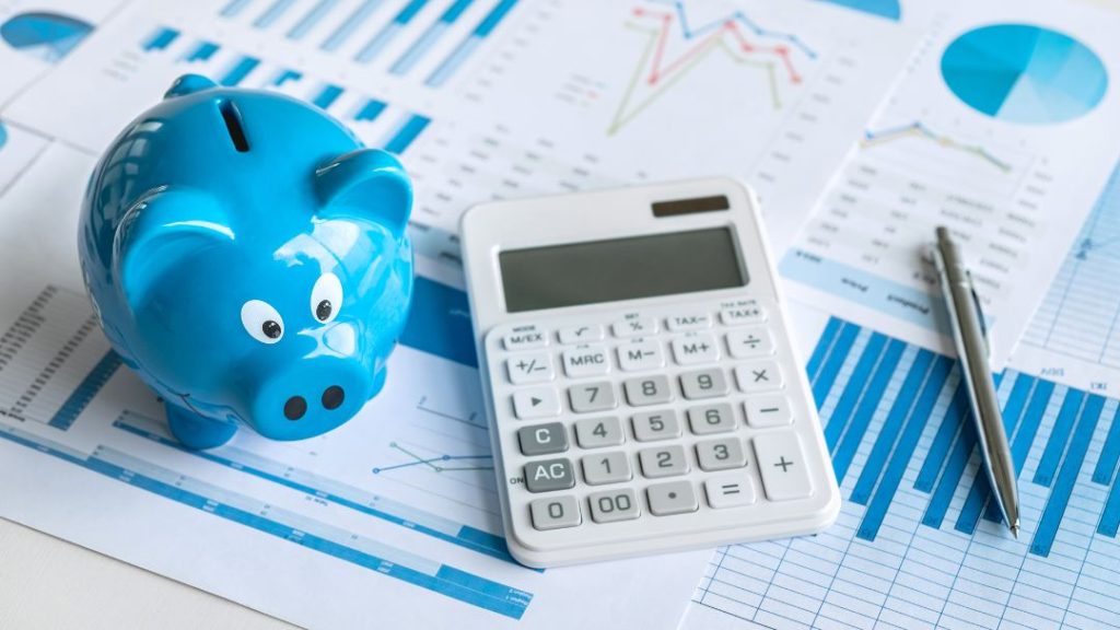 piggy bank, calculator, and pen with graph documents