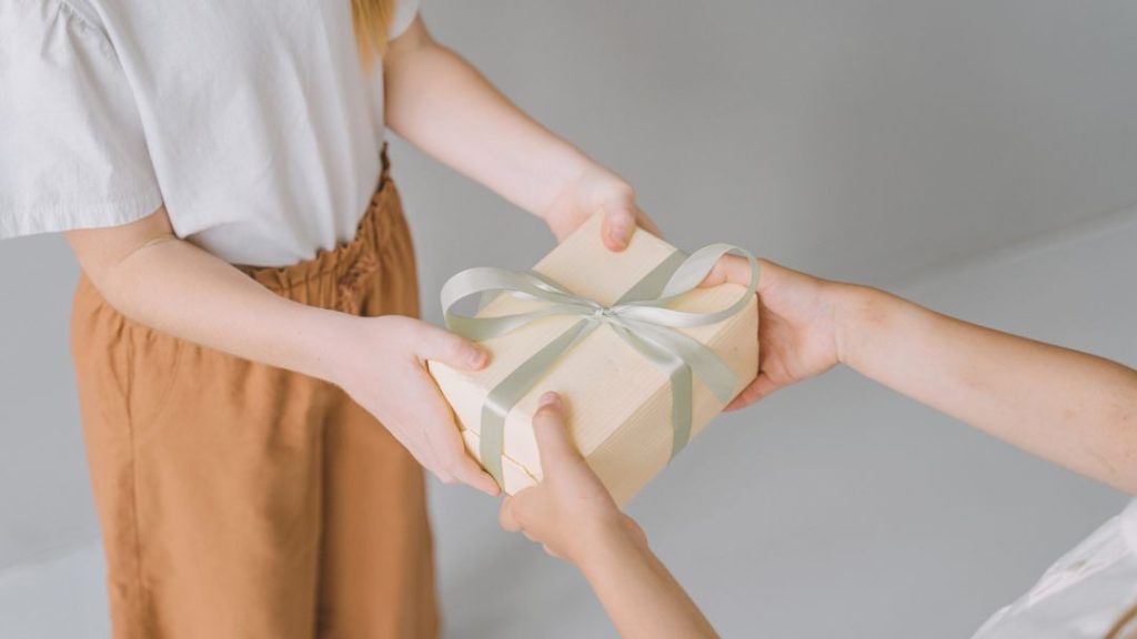 two people handling gift
